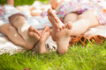 two sisters feet lying on grass at park - PhotoDune Item for Sale