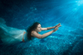 beautiful woman in dress comes up from pool at beam of light - PhotoDune Item for Sale