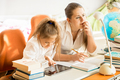 mother sitting next to daughter doing homework - PhotoDune Item for Sale