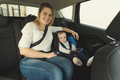 Portrait of smiling mother and baby boy in car safety seat - PhotoDune Item for Sale