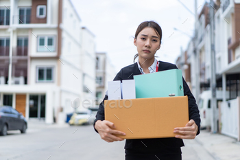 ployment from company. Young attractive girl employee worker hold a box, feeling sad after losing the job due to world economic problem from covid 19
