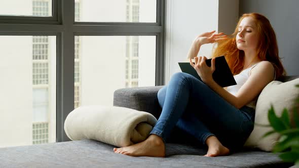 Woman reading a book in living room 