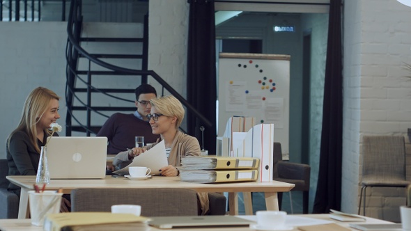 Two women having coffee break together in office