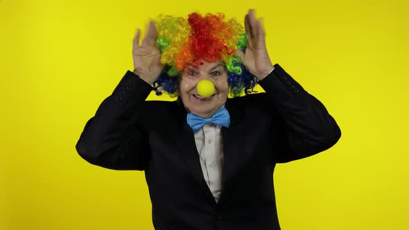 Senior Old Woman Clown in Colorful Wig Smiling, Making Silly Faces, Fool Around