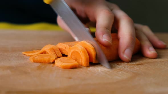 Woman Cut Carrots Into Slices on a Cutting Board Close-up