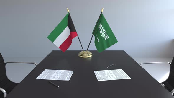 Flags of Kuwait and Saudi Arabia and Papers on the Table