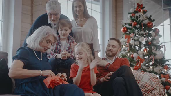 Grandmother Opens Her Gift and Hugs with Whole Family on Christmas Morning