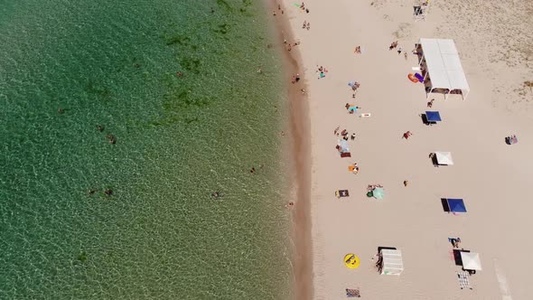 Aerial View of Azure Beach of Central Asia with Tourists Resting and Beach Umbrellas Top View