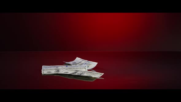 American $100 Bills Falling onto a Reflective Surface - MONEY 0031