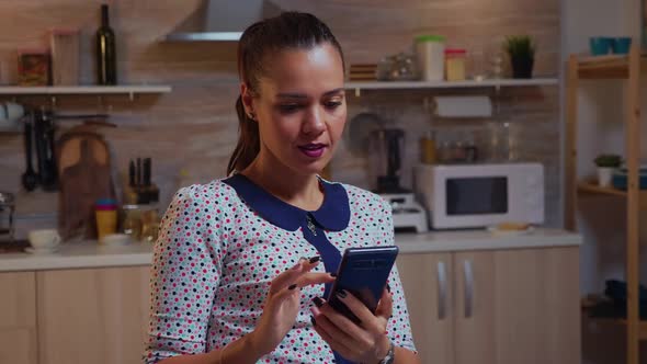 Freelancer Texting on Phone While Working Remotely