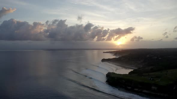 Dramatic sunset at Balangan Beach in Bali Indonesia with Kuta Golf Course over the cliffs right, Aer