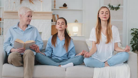 Calmed Pacified Relaxed Young Mother and Daughter Doing Meditation with Closed Eyes Sitting Together
