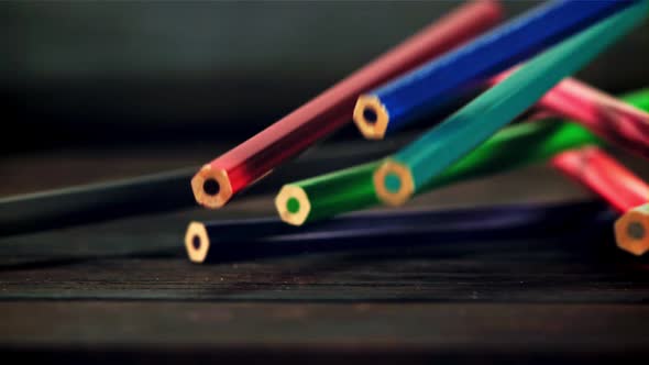 Colored Pencils Fall on a Wooden Table