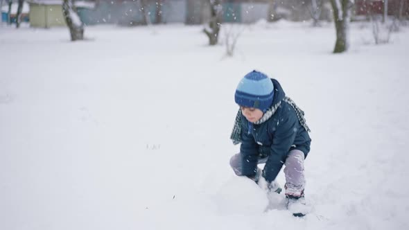 Boy Making Snowball for Snowman alt