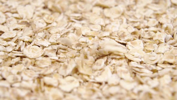 Oat flakes fall in a heap closeup. 