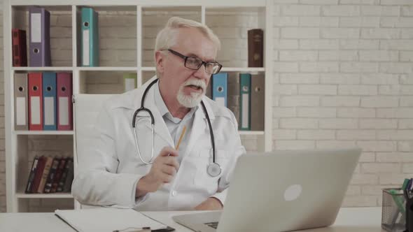 Telemedicine Concept. Senior Doctor Talking with Patient Using Laptop Online Video Webinar