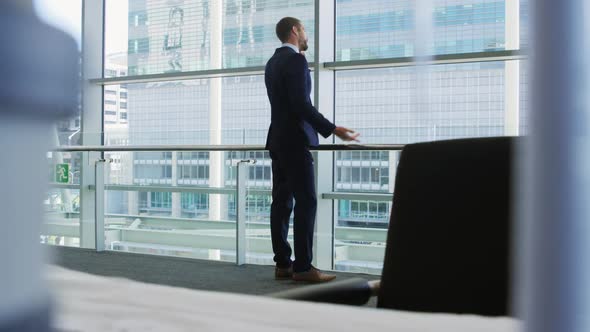 Businessman on smartphone in modern office building