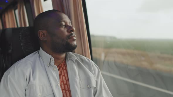 African American Man Looking at Window during Bus Ride