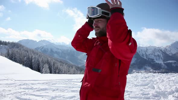 Skier putting on helmet and goggles and moving off