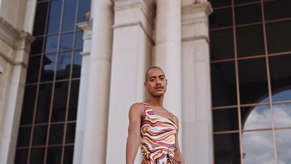 Man With Moustache And Shaved Head In Bright Fashionable Clothing