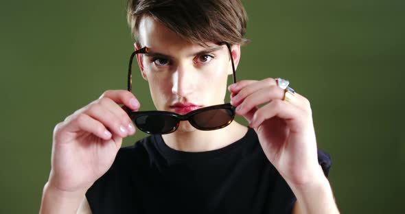 Androgynous man posing against green background