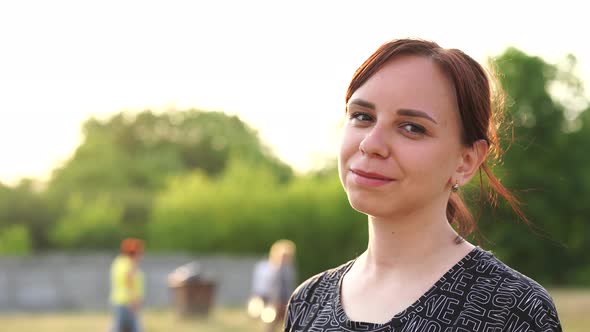 Portrait of Young Smiling Woman on Street During Sunset