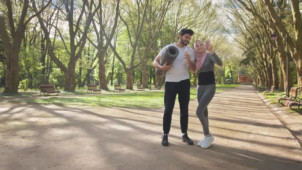 Young Muslim Couple in Sport Clothes Using Modern Smartphone for Taking Selfie