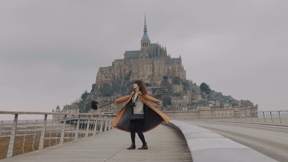 Beautiful Happy Freelance Blogger Woman Spinning with Arms Open, Posing at Amazing Mont Saint Michel