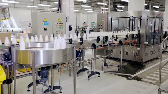 Conveyor At The Enterprise For Dividing Liquids Into White Plastic Bottles