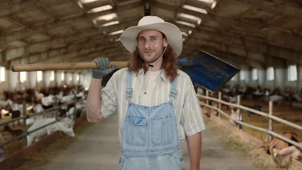 Young Redhead Man Standing with Shovel at Goat Ranch