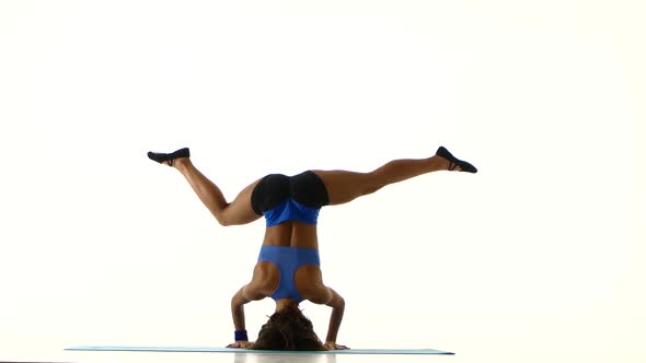 Athlete Stands on His Head and Trains the Body. White