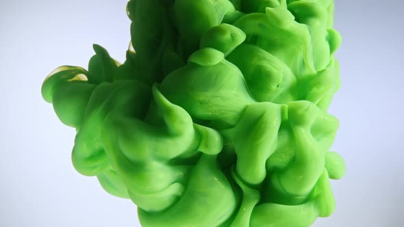 Green Color Paint Drops in Water Against White Background alt