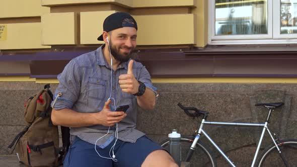 Cyclist Shows His Thumb Up on the Street