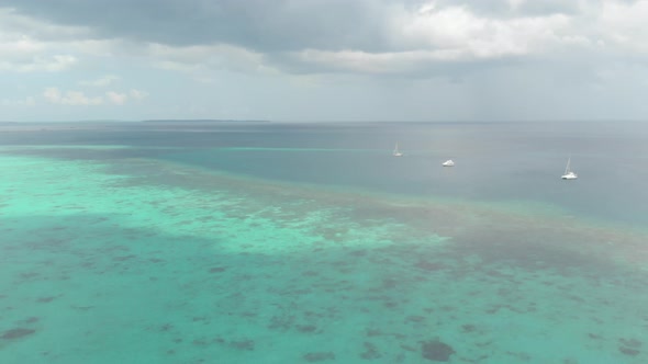 Aerial: flying over tropical beach coral reef turquoise water green forest uncon