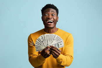 lding bunch of money cash on blue studio background, showing happiness, copy space. Loan, wage, salary, lottery, gaming, gambling, trading concept