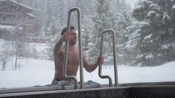 Close-up of a man stepping out of a pool at a luxury spa resort.