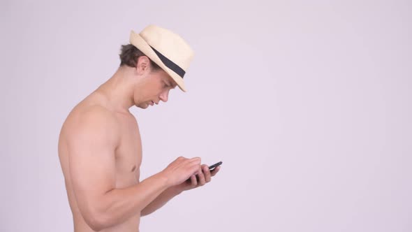 Handsome Muscular Tourist Man Thinking While Using Phone Shirtless
