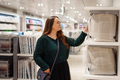 Young focused woman doing shopping in store mall in bedding department - PhotoDune Item for Sale