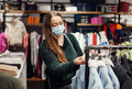 Photo of young mother in face mask walks around mall doing shopping - PhotoDune Item for Sale