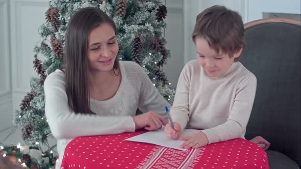 Happy Mother and Her Son Writing Letter To Santa