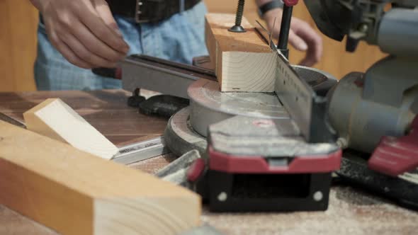 Sawing a Wooden Block with a Cutting Saw in a Carpentry Workshop.