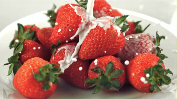 Super Slow Motion on Fresh Strawberries in a Plate Pours Milk