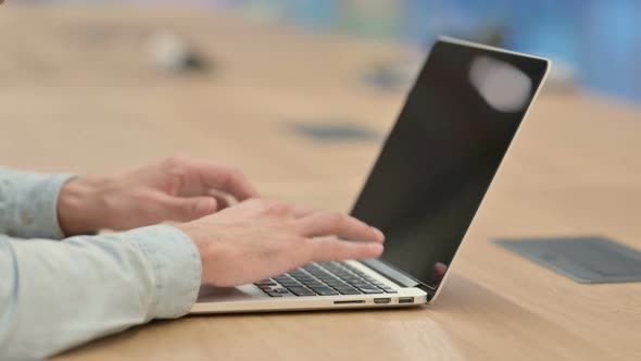 Close Up of Creative Young Man Typing on Laptop