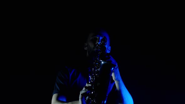 Live Performance of Saxophonist Man with Saxophone Dancing on Concert Stage with Blue Neon Lights