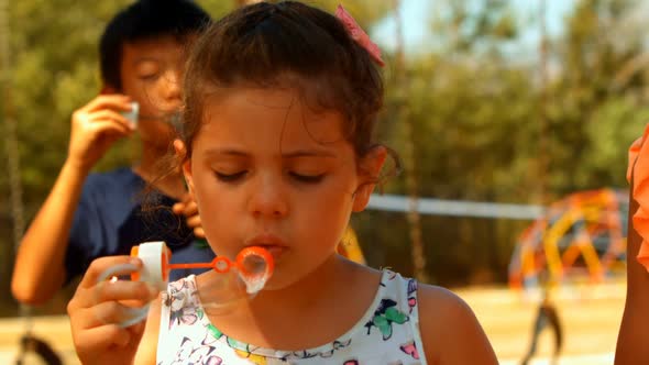 Close-up of schoolkids playing with bubble wand