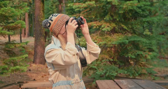 Woman Taking Picture of Fall Forest on Camera on Sunny Cold Autumn Day