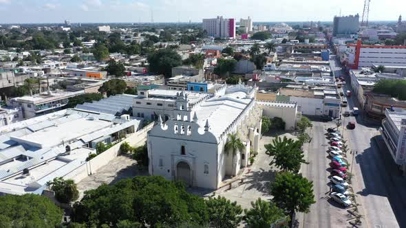 Aerial camera ascending from the side of and pitching down onto the colonial Church of Santiago Apos