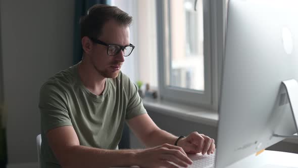 Intelligent Young Man Wearing Stylish Eyewear Working Remotely From Home