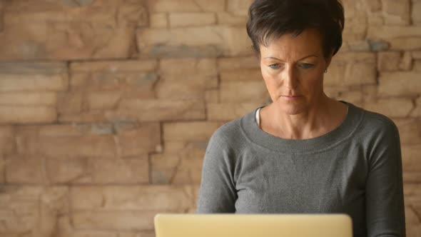 Mature Beautiful Woman Using Laptop and Drinking Coffee