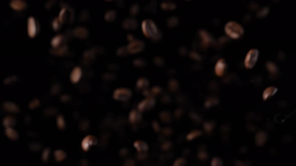 Roasted coffee beans in slow motion. Coffee beans in a free fall.